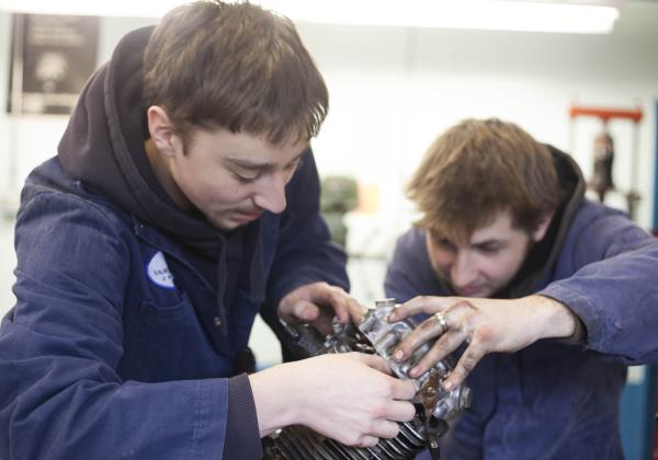Students of the Marine Technician and Motorcycle Mechanic program repairing an engine