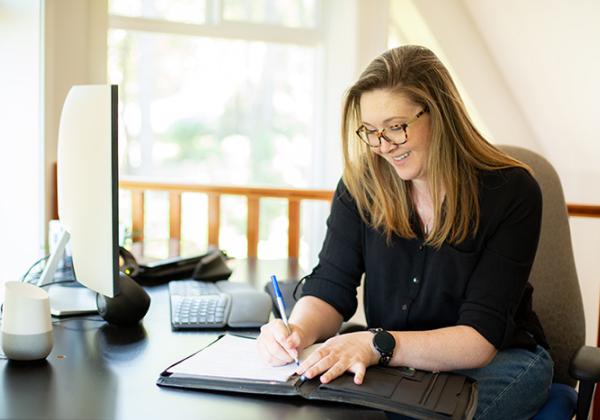 Woman writing at a desk. 