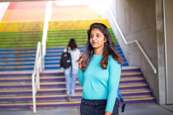 Young woman standing near a rainbow staircase