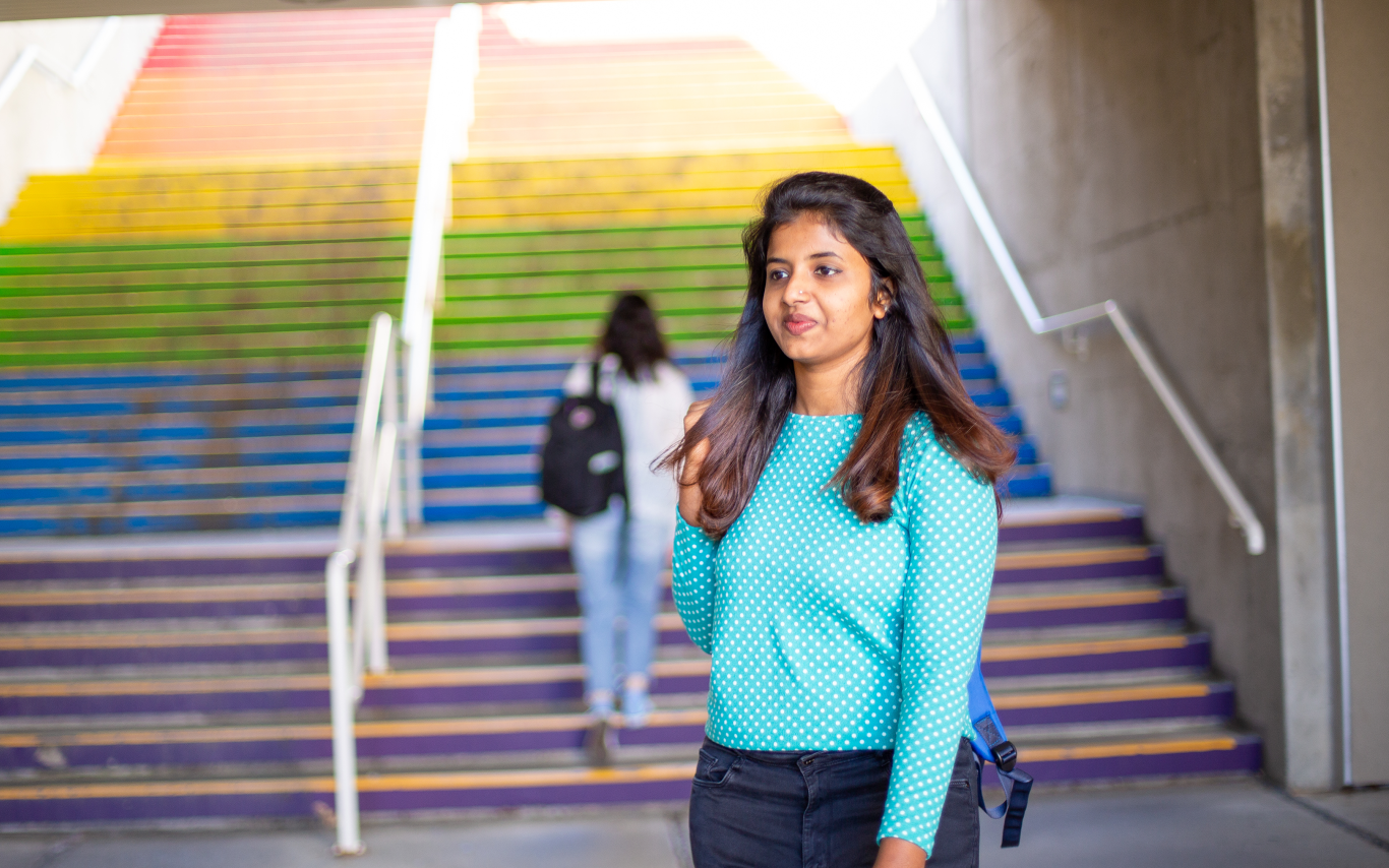 Young woman standing near a rainbow staircase