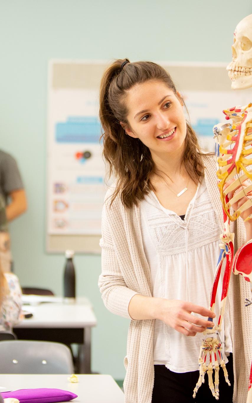 Kinesiology students around a human skeleton model